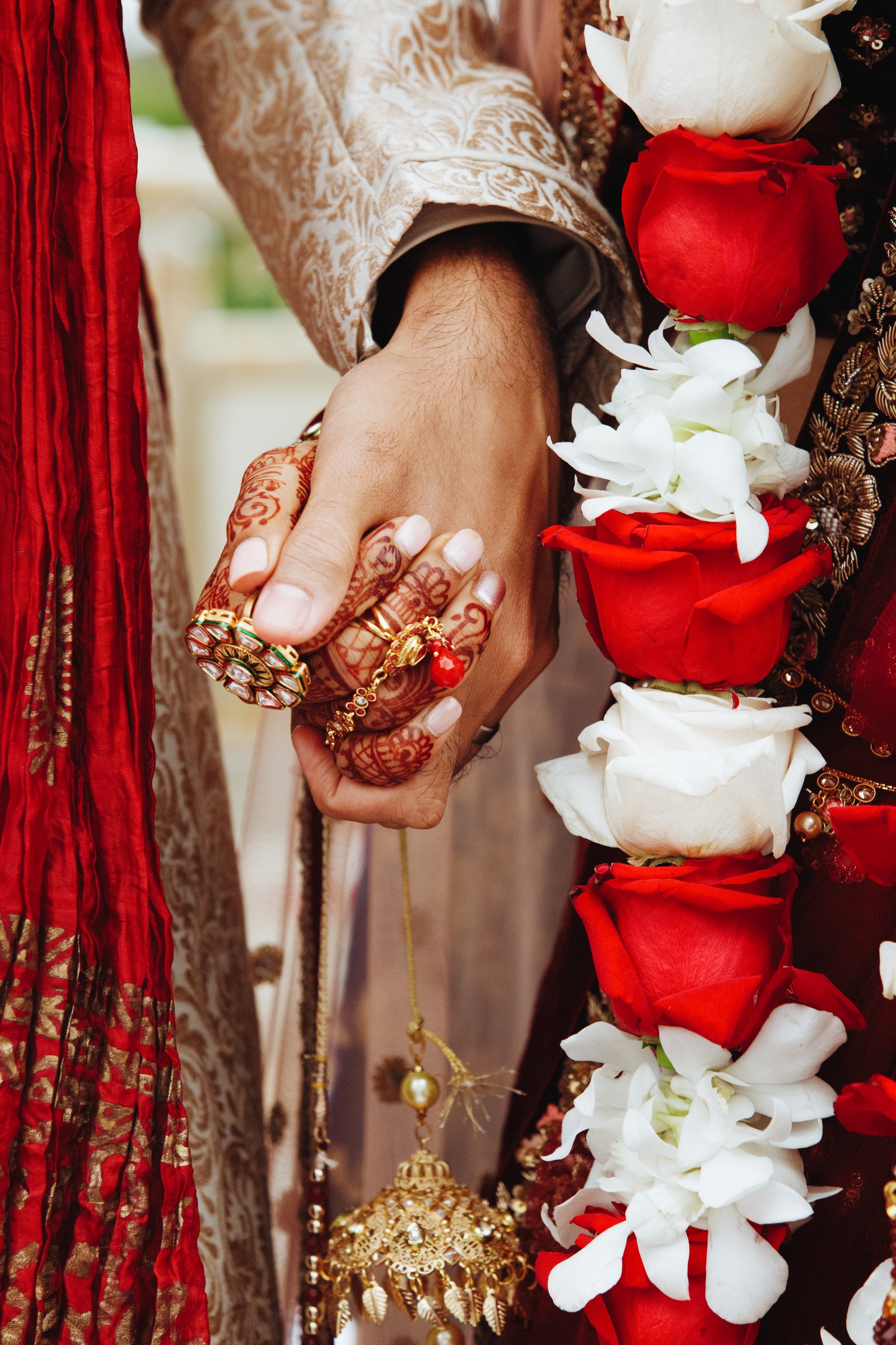 Indian bride and groom holding hands in traditional wedding attire